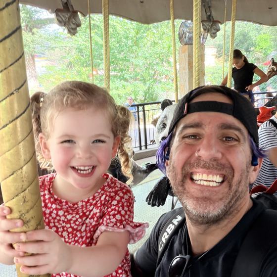 Mike and his daughter on a carousel